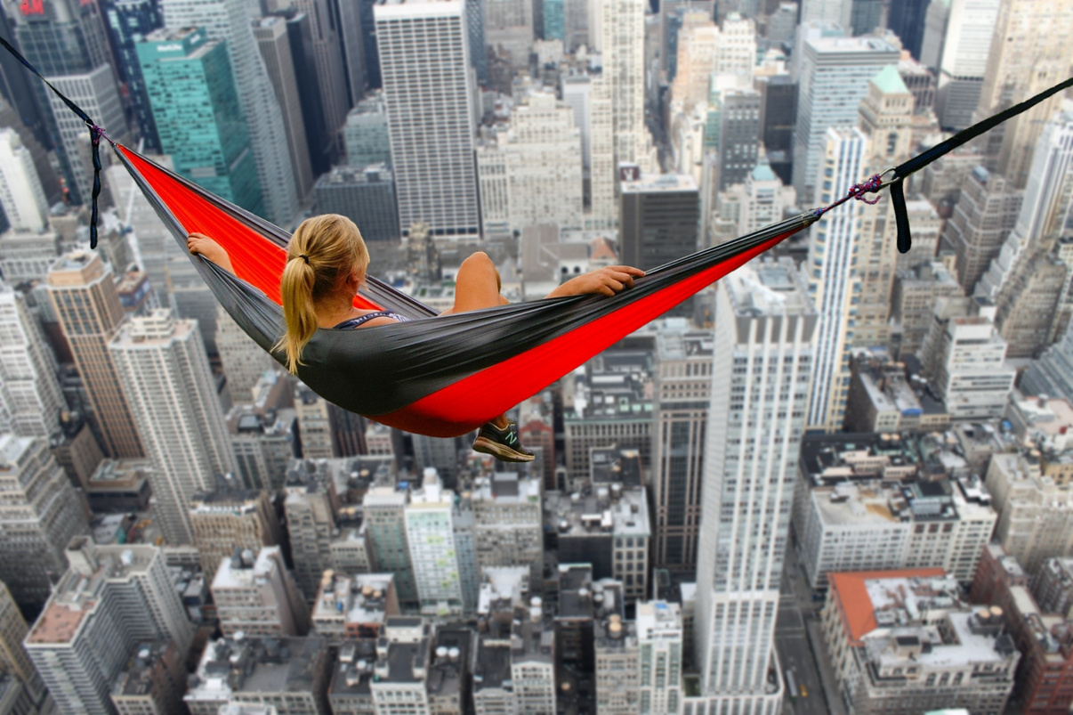Person in a Hammock Above Buildings